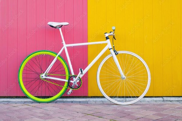 City bicycle fixed gear on yellow and red wall.