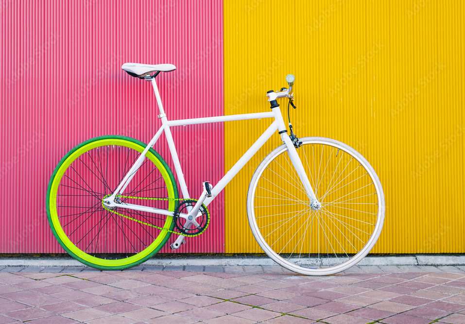 City bicycle fixed gear on yellow and red wall.