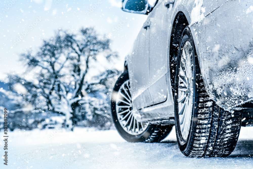Tire in winter on snow road. Winter tires with car detail.