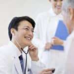 Male doctor examining patient with stethoscope