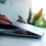 Closeup image of hands close and open a laptop computer on table after finished using it